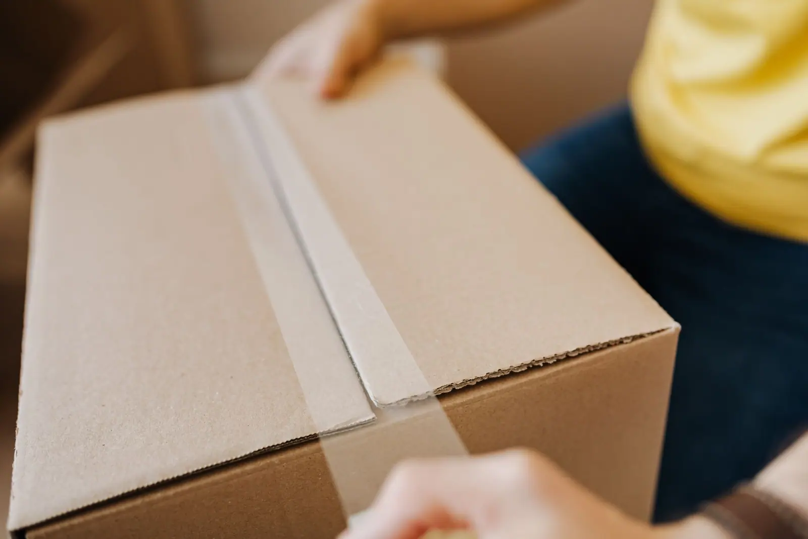 Hands holding an open cardboard shipping box